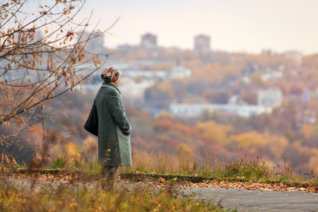 Old Widow Walking in Autumn City Park